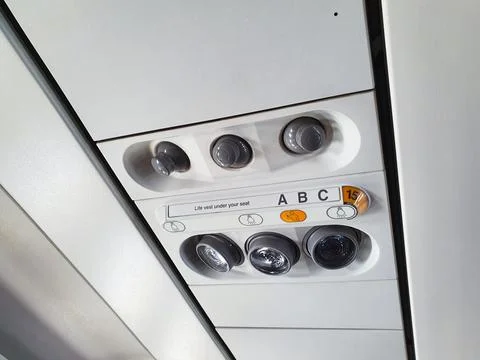 Passenger airplane overhead console with ventilation air nozzles and light Stockfoto's