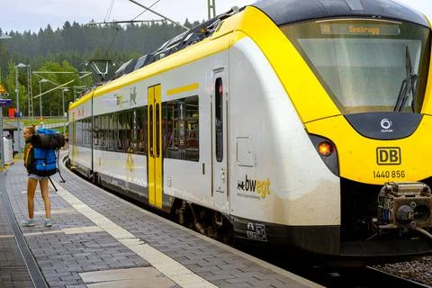 Passenger with backpack next to passenger train. Schluchsee, Baden-Wrttemberg Stock Photos