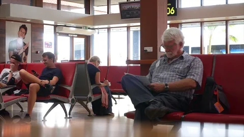 Passenger at boarding hall playing smart phone  Stock Footage 99295695