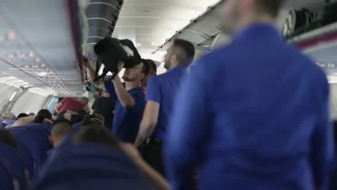 Passenger boarding on plane and putting luggage on overhead locker compartment s Stock Footage 220372767