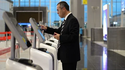 Passenger business man at the airport check in ticket at kiosk terminal Stock Footage