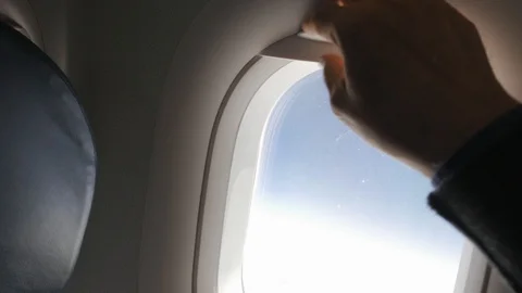 Passenger closing the window shade on an airplane. Video stock 110894992