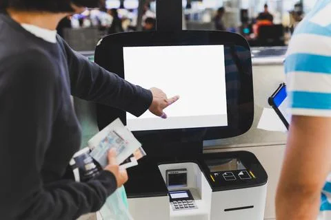 Passenger couple doing self check in kiosks at International Airport. Stock Photos