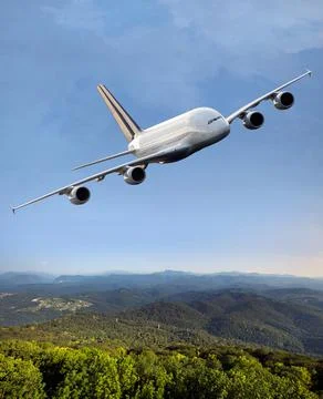Passenger double decker plane fly above the green hills Stock Photos