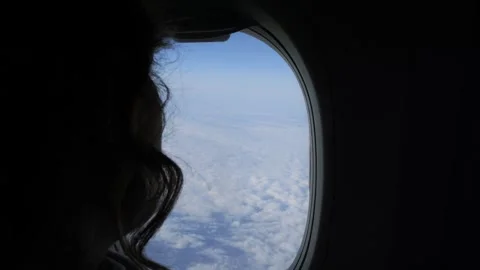 Passenger enjoying clouds view from airplane window, experiencing scenic sky Stock Footage 276965398