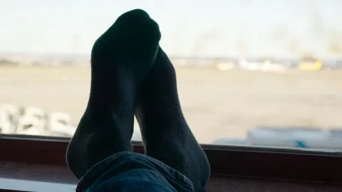 Passenger feet resting on huge window in the waiting room Stock Footage 309061953
