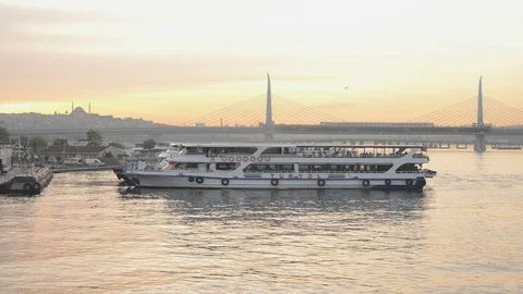 A passenger ferry sails across the frame with Haliç bridge in the background Stock Footage 90690763