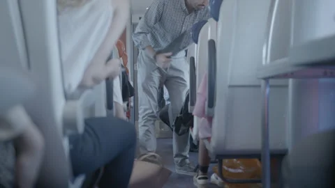Passenger Getting Luggage from Overhead Bin on Train Stock Footage 344603770
