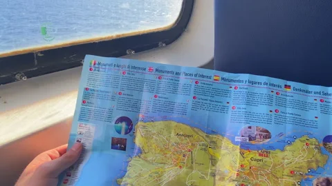 Passenger holding a map of Capri island inside the traveling ferry Stock Footage 263909441