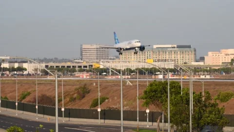 Passenger Jet Descends Toward LAX Runway Beyond Airport Boulevard Stock Footage 300825616