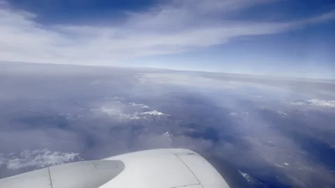 Passenger jet flying in clouds above the ground with the view on engine, amazing Stock Footage 318219807