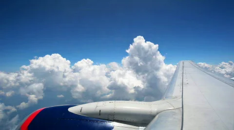 Passenger Jet flying through puffy clouds Stock Footage