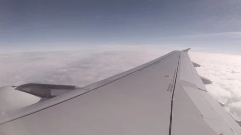 Passenger jet plane flying high through the clouds.  Stock Footage 99845005