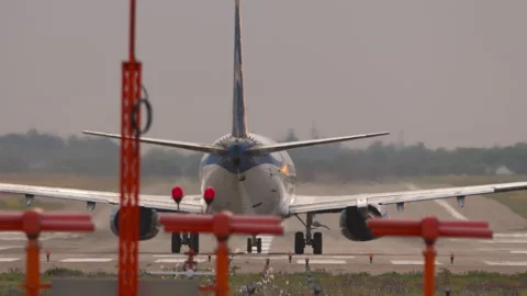 Passenger jet starting takeoff roll on airport runway rear view Stock Footage 337663735