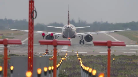 Passenger jet starting takeoff roll on airport runway rear view Stock Footage 340480505