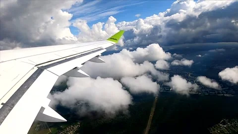 Passenger jet winglet during scenic turn above cumulus clouds, window view Stock-Footage 337427150