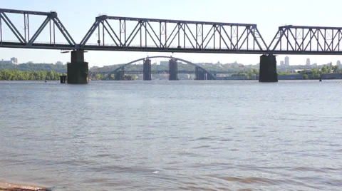 Passenger long train rides across the bridge over the river. Stock-Footage 37874468