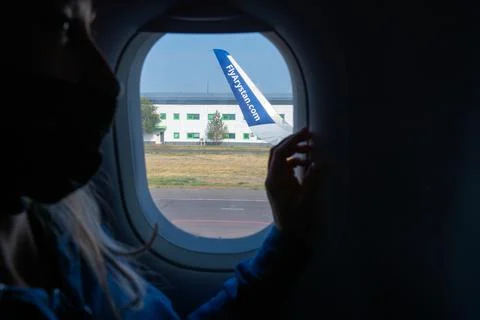 A passenger is looking through the airplane window Stock Photos