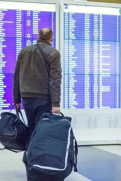 Passenger looking at timetable board Foto stock