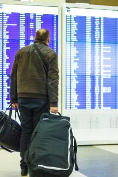 Passenger looking at timetable board Stock Photos