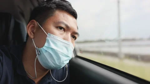 Passenger man in a protective mask in the back seat of a car. Lonely car of a Stock Footage 154533132