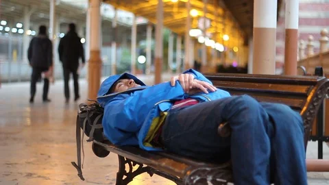 Passenger man sleeping on bench at train station Stock-Footage 100605296