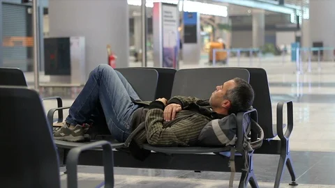 Passenger man sleeping while waiting the plane at airport terminal Stock Footage 100581320
