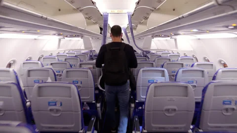 Passenger man walking down the aisle inside an airplane, follow shot Video stock 320118861