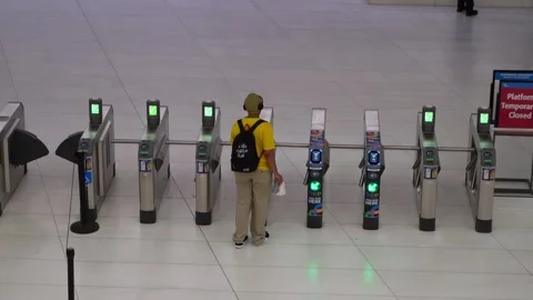 Passenger Navigating Through Automated Turnstiles in a Modern Train Station Vidéo 291635535