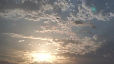 A passenger plane flies against the background of a sunset, cloudy sky Stock Footage 220404432