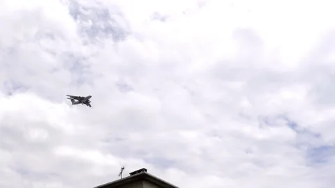 The passenger plane flies in the cloudy sky over the city houses Stock Footage 98394089