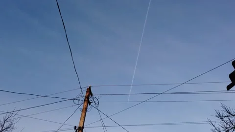 A passenger plane flies high in the sky and leaves a smoke trail behind it. Vídeos de archivo 169494584