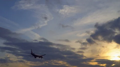 Passenger plane flies overhead. Sunset in the background. UltraHD stock footage Stock Footage 105701341