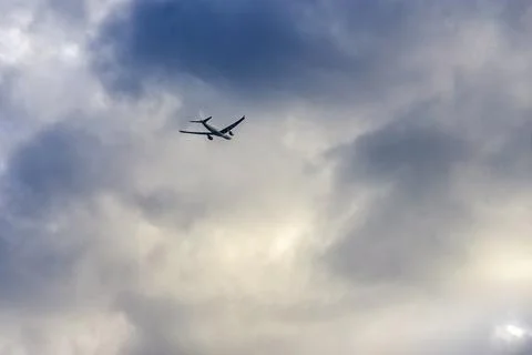 A passenger plane flies towards the thunderclouds Foto stock