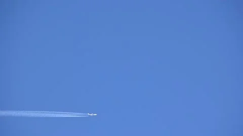Passenger plane fly high in the sky leaving water vapor contrails behind Stock-Footage 150834313