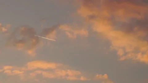 Passenger plane flying high in cloudy blue sky in the sunset Stock Footage 142669078