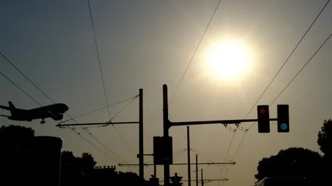 Passenger plane flying over the traffic lights Stock Footage 295493844