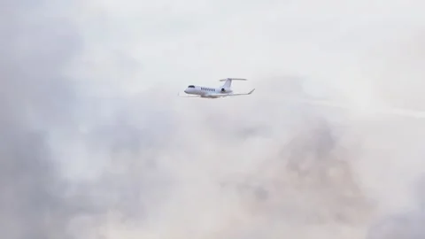 Passenger Plane Flying Through Dense Clouds, Leaving Behind a Striking Contrail Stock Footage 253890510