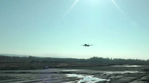The passenger plane glinting in the sun comes nearer to a landing place Stockbeeldmateriaal 20519989