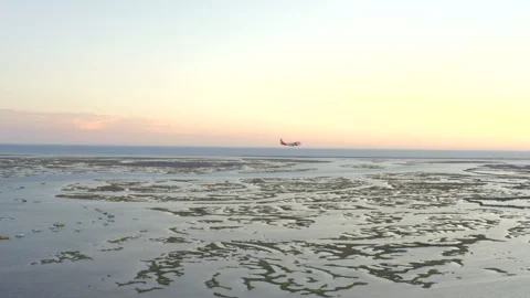 Passenger plane landing over Ria Formosa lagoon in Faro Algarve sunset Vídeo Stock 327716630