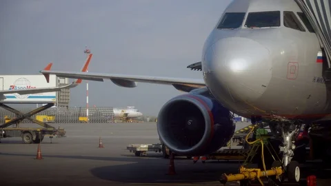 A passenger plane is preparing to fly. Refuelling. baggage loader pulls up to Stock Footage 123853965