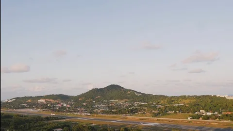 Passenger plane in a sky landing on a background of mountains and palm trees. A Stock Footage 128491836