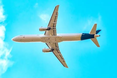 Passenger plane in the sky, view from below, closeup. Commercial air travel. Stock Photos