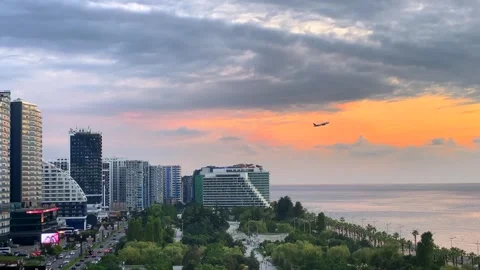Passenger plane taking off wide shot over Batumi coastline at sunset Stock Footage 345361623