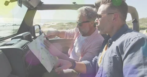 Passenger pointing at coastline and driver unfolding map in SUV, both matching Stock Footage 332286014