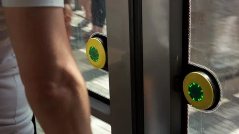 Passenger push the button on a tram doors and getting in through opened doors Stock Footage 85477596
