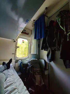 A passenger relaxing inside a sleeper cabin on a Finnish train, showing hangi Stock Photos