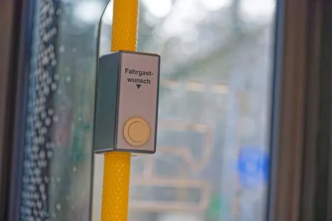 Passenger request stop button on yellow pole inside public transport vehicle Stock Photos