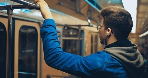 Passenger rides while standing in the car and holds on to the rail. Guy listens Stock Footage 108565483