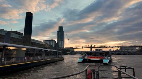 Passenger river bus backs into Bankside Pier at sunset with towers and clouds Stock Footage 342186276